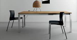 Extendable tables inhardwood with lamp on it and black chairs around